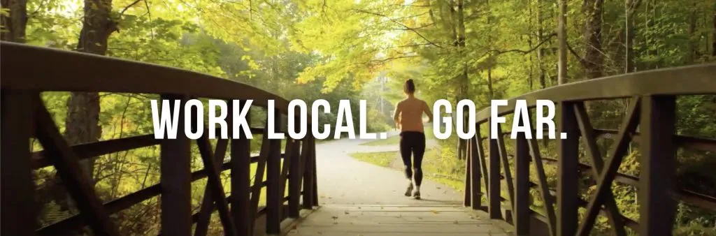 A woman is running over a bridge with "Work Local. Go Far."
